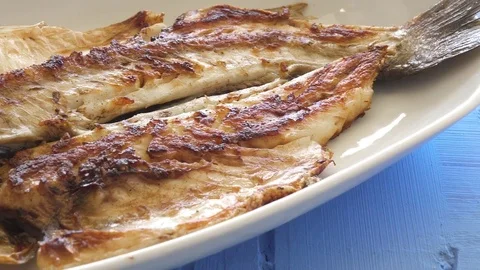 Grilled fish on the plate close up pan shot. Well done cook.  Vídeos de archivo 80314286