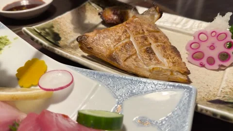 Grilled Fish Served with Lemon and Pickled Vegetables in Japanese Restaurant Vídeo Stock 320090649