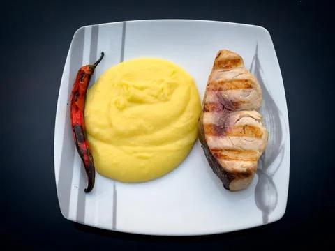 Grilled fish served with mashed potatoes and a roasted pepper Stock Photos