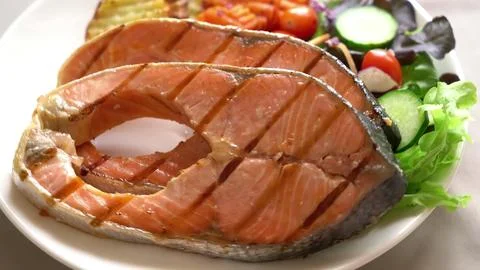 Grilled fish steak with vegetable salad on a plate Stock-Fotos