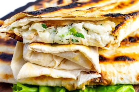 Grilled flatbread wraps filled with savory cheese and herbs Stock Photos