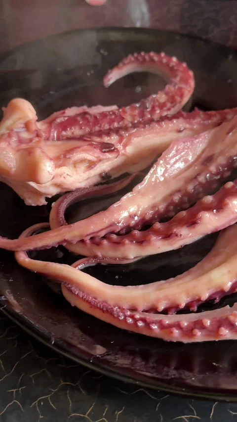 Grilled giant squid tentacles served with lemon and herbs as a gourmet seafood Stock Footage 345176477