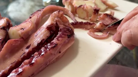 Grilled giant squid tentacles served with lemon and herbs as a gourmet seafood Stock Footage 345183109