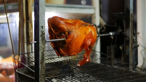 Grilled half of chicken on automatic spit, night asian market. 4k Stock Footage 104141519