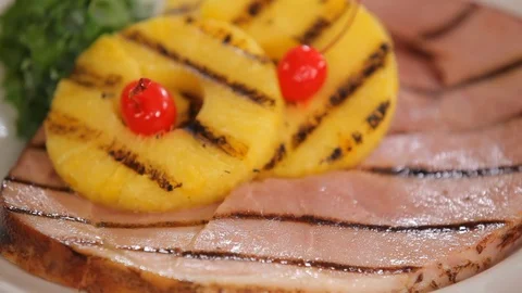 Grilled ham cuts with pineapple slices on plate with garnish B Stock Footage 114990508