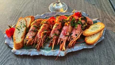 Grilled jumbo prawns with bread and beer served on a platter at sunset Video stock 334691873