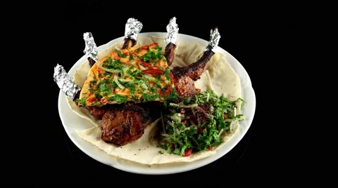 Grilled lamb chop with pita bread and vegetables, loop, top view Video stock 61708424