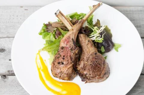 Grilled lamb chops on a bed of vegetables Stock Photos