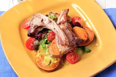 Grilled lamb chops with cherry tomatoes and potatoes Stock Photos