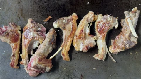 Grilled lamb chops sizzling on a hot plate Video stock 344100270