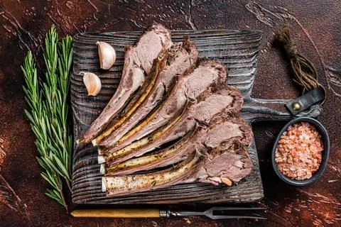 Grilled Lamb mutton Ribs Chops steaks on wooden board. Dark background. Top view Stock Photos