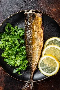 Grilled Mackerel Scomber fish on a plate with greens and lemon. Dark backgr.. Stock Photos