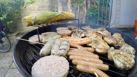 Grilled meat and corn on barbecue getting ready for a family picnic Stock Footage 79927018