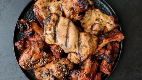Grilled meat set featuring chicken breast, wings, and ribs seasoned with spices. Stock Footage 345109000