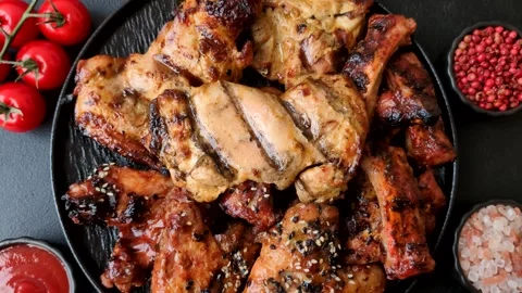 Grilled meat set featuring chicken breast, wings, and ribs seasoned with spices. Stock Footage 345109009