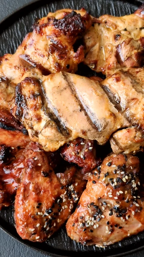 Grilled meat set featuring chicken breast, wings, and ribs seasoned with spices. Stock Footage 345109038