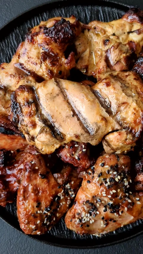 Grilled meat set featuring chicken breast, wings, and ribs seasoned with spices. Stock Footage 345109049