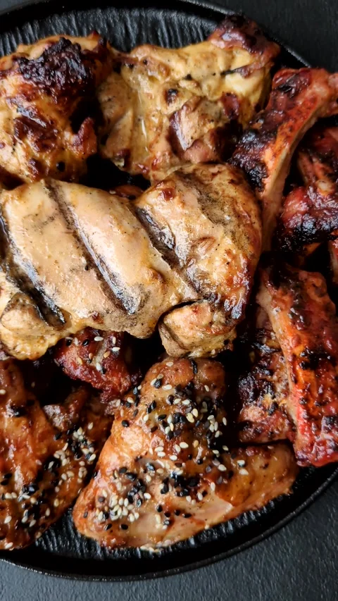 Grilled meat set featuring chicken breast, wings, and ribs seasoned with spices. Stock Footage 345109067