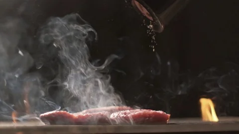 Grilled meat steak. Cooking on fire. Slow motion Beef steak close-up. The cook Stock Footage 108608922