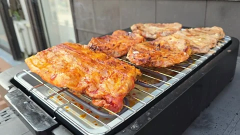 Grilled meat steaks and ribs finishing cooking on electric grill grate Stock Footage 344700986