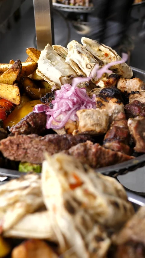 Grilled meat with vegetables on a plate before serving Stock Footage 310343566