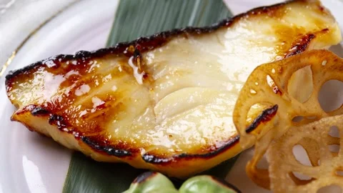Grilled miso cod with lotus root on white plate 動画素材 337352304