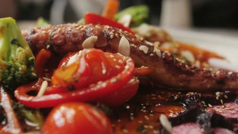 Grilled octopus on plate with vegetables close up shot. Asian food. Stock Footage 238836175