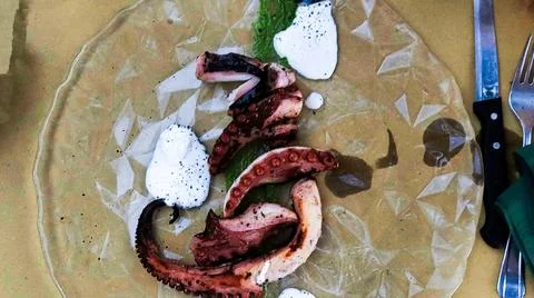 Grilled octopus on a serving platter cooked in a restaurant Stock Photos