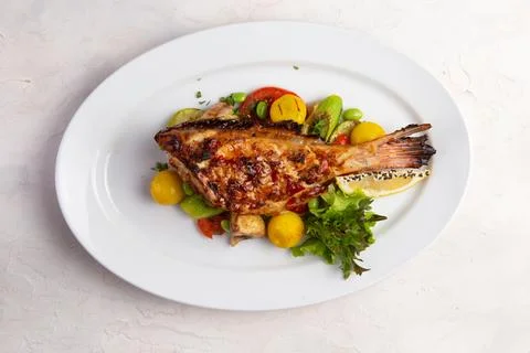 Grilled perch in a bowl. On a light background. Stock Photos