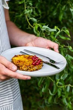 Grilled pineapple slice served with red currant on plate. Man, holding a plat Stock Photos