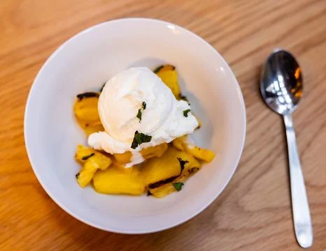 Grilled pineapple slices complemented with vanilla ice cream Stock Photos