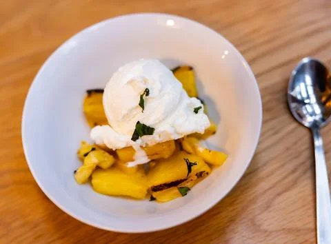 Grilled pineapple slices complemented with vanilla ice cream Stock Photos