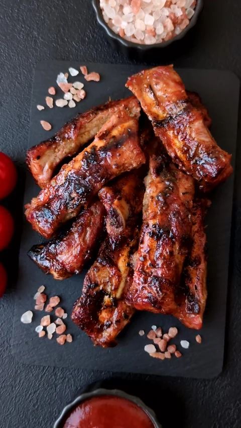 Grilled pork or beef ribs seasoned with salt and spices, served in sauce. Grille Stock Footage 345108857