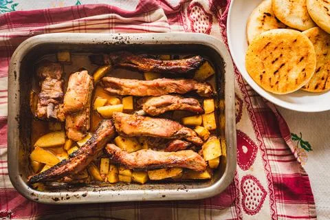 Grilled pork ribs on table inside oven aluminum container with venezuelan are Stock Photos