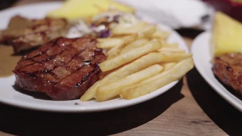 Grilled pork steak served on a white plate with crispy golden french fries,.. Stock Footage 343114669