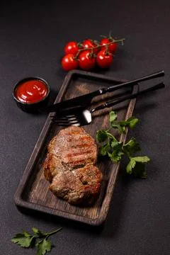 Grilled pork steak serving with cherry tomatoes and sauce Stock Photos