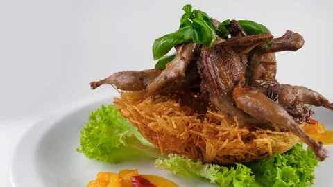 Grilled quails in white plate, decorated with roasted potato and vegetables Stock Footage 80142683