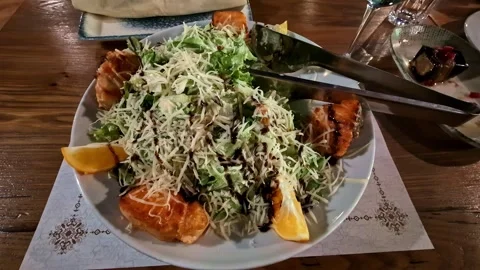 Grilled salmon caesar salad served with parmesan cheese and lemon in a Stock Footage 337925589