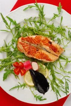 Grilled salmon fillet with mussels and rocket salad Stock Photos