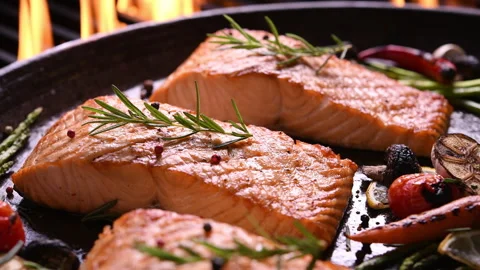 Grilled salmon fish with various vegetables on pan on the flaming grill 库存影片 130924644