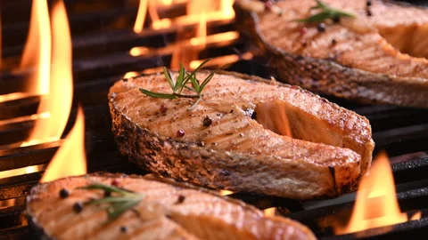 Grilled salmon fish with various vegetables on the flaming grill Stock Footage 145188621