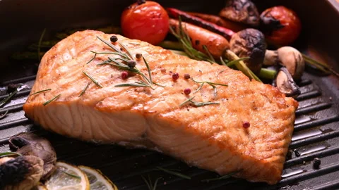 Grilled salmon fish with various vegetables on pan on the flaming grill Видео 145675481