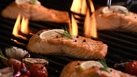 Grilled salmon fish with various vegetables on the flaming grill Video stock 145675557
