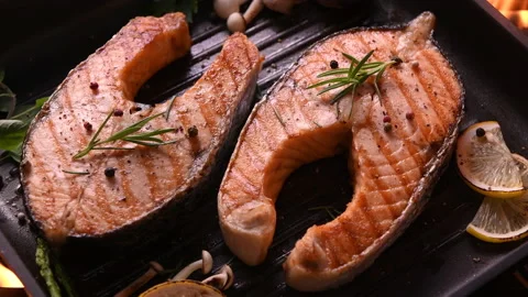 Grilled salmon fish with various vegetables on pan on the flaming grill 库存影片 146201922