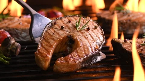 Grilled salmon fish with various vegetables on the flaming grill Video stock 147241111