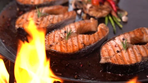 Grilled salmon fish with various vegetables on pan on the flaming grill Stock Footage 149293117