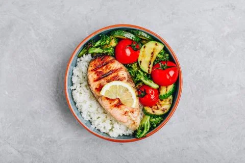 Grilled salmon steak with and rice, zucchini, broccoli, tomato . Stock Photos