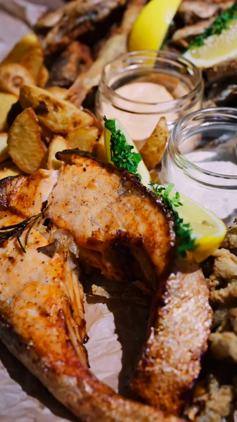 Grilled salmon steak with roasted potatoes and sauces in closeup cinematic .. Stock Footage 339411677