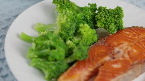 Grilled salmon steak with steamed broccoli on white plate Stock Footage 346026886