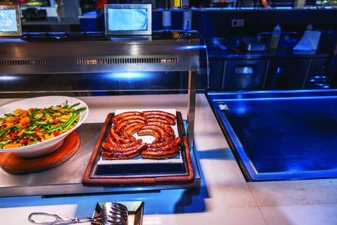 Grilled sausages arranged in a circular pattern on buffet display Stock Photos